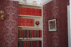 a book shelf filled with lots of red books at Varley House in Ilfracombe