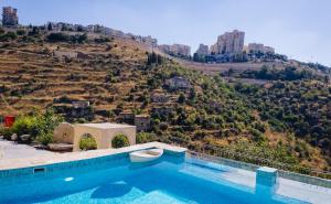 a swimming pool with a view of a hill at Lifta Boutique Hotel & Spa in Jerusalem