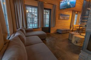 a living room with a couch and a tv at Tunturipöllö 3 in Ruka
