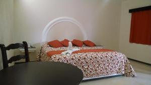 a bedroom with a bed with a black table and a table at Hotel Plaza Hidalgo in Ixtlán del Río