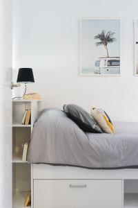 a white bedroom with a bed and a palm tree at Lux&Cool Obispo Orberá - Santa Rita in Almería