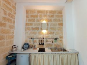 cocina con fregadero y pared de ladrillo en Bed & Breakfast Casa Lopez, en Barletta