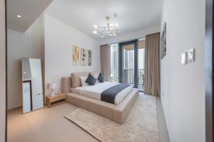 a bedroom with a bed and a couch and a window at EDEN'S Homes & Villas - BLVD Heights in Dubai