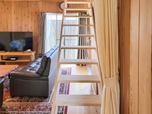 宜野座村にあるペンション スナドゥンのソファのあるリビングルームにある木製のはしご