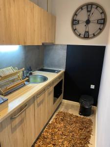 科帕奥尼克Аpartman 511 Zupa的厨房配有水槽和墙上的时钟 更多9张照片