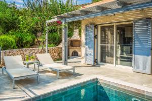 a patio with two chairs and a swimming pool at Kaminia Cottage in Ratzaklíon