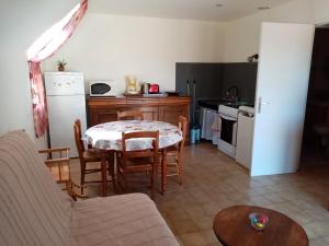 a living room with a table and a kitchen at Gîte Marguerite in Les Moitiers-en-Bauptois