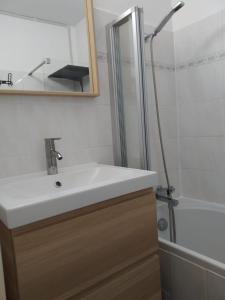 y baño con lavabo blanco y ducha. en Appartement agréable à deux pas du plan d'eau, en Embrun