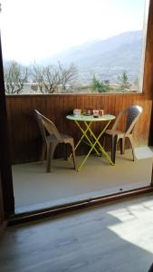uma mesa e cadeiras numa varanda com vista em Appartement agréable à deux pas du plan d'eau em Embrun
