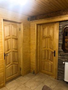 Habitación con 2 puertas de madera en una casa en Зимова казка, en Tatariv