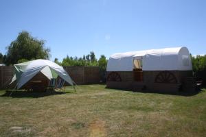 une tente et une table dans une cour dans l'établissement Camping Les Chagnelles, au Perrier