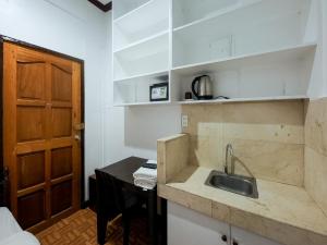 a kitchen with a sink and a table and a door at OYO 857 City Stay Inns Makati Avenue in Manila