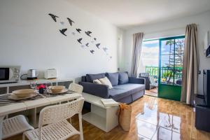 un soggiorno con un divano e un tavolo di Moya a Tías