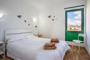 una camera con un letto bianco e una porta verde di Moya a Tías Altre 72 foto