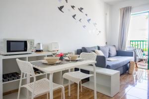 un soggiorno con un tavolo e un divano blu di Moya a Tías