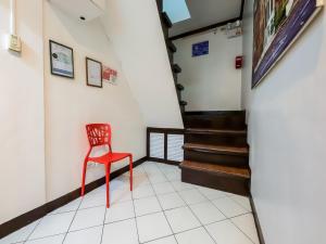 a red chair in a hallway with stairs at OYO 857 City Stay Inns Makati Avenue in Manila