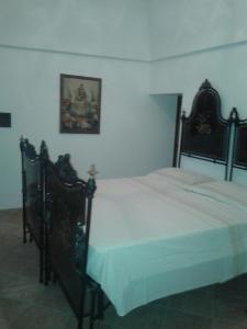 オストゥーニにあるvilla ottocentoのベッドルーム(白いシーツを使用した大型ベッド1台付)