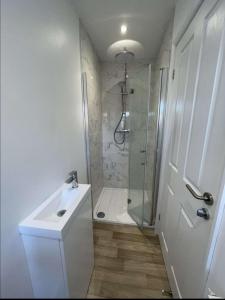 a white bathroom with a shower and a sink at A beautiful house in a scenic town location. in Louth