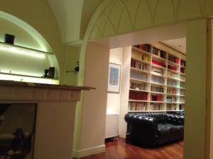Loft Piazza Università في كاتانيا: غرفة معيشة مع أريكة ورف كتاب