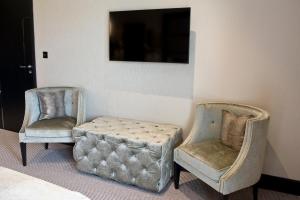 two chairs and a ottoman in a room at The Lodge at Kingswood in Epsom