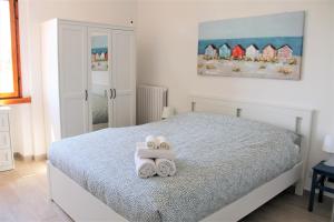 a bedroom with a bed with two towels on it at Casa Luce Sabaudia in Sabaudia