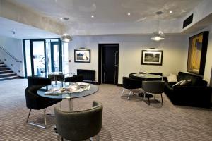 a living room with a couch and a table and chairs at The Lodge at Kingswood in Epsom