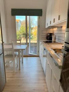 a kitchen with a table and a table and a window at Toppmodern familjelägenhet nära Kalmar slott och långviksbadet in Kalmar