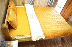 a yellow bed with two pillows on top of it at Mu Cang Chai Homestay & Trekking in Mù Cang Chải