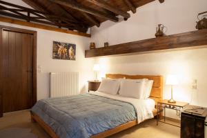 - une chambre avec un lit et deux lampes sur les tables dans l'établissement Guesthouse Ourania, à Palaios Panteleimonas