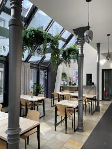 um restaurante com mesas, cadeiras e janelas em Vierzigerhof em Langenlois