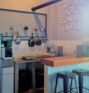 a kitchen with a counter and stools in it at Bed Attitude Hostel Cenang in Pantai Cenang +47 photos