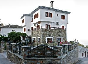 a large white house on a stone wall at Guesthouse Papagiannopoulou in Zagora