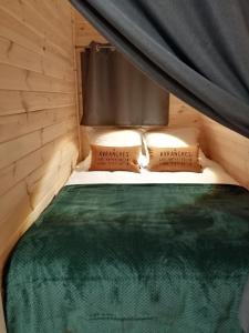 a bedroom with a bed with a canopy and two pillows at Le Domaine de Pivette Chambre climatisée et insolite avec terrasse privative in Avranches