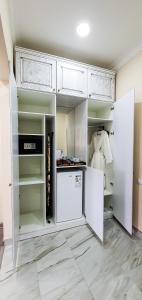 a kitchen with white cabinets and a refrigerator at Grand Holiday Hall in Pavlodar