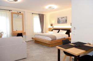 una camera da letto con un letto, una scrivania e un tavolo di Roloi suites a Nafpaktos