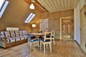 a living room with a table and chairs and a couch at Familienferienhaus "Zur Alten Wäscherei" in Schmiedefeld am Rennsteig