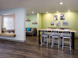 - une salle d'attente avec une table et des chaises dans l'établissement WoodSpring Suites Cedar Park - Austin North, à Cedar Park