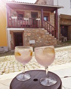 two wine glasses sitting on a table in front of a house at Casa Freixedelo in Santa Comba de Rossas