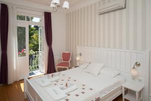 ブユカダにあるCenar Konak Butik Hotelの白いベッドルーム(ベッド1台、窓付)