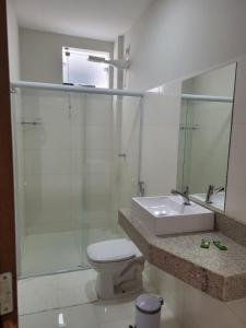 a bathroom with a toilet and a sink and a mirror at NOVO HOTEL in Conceição do Coité