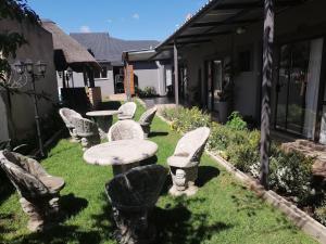 un grupo de sillas y una mesa en un patio en FRANCHISE BENONI GUEST HOUSE en Benoni