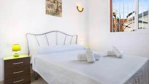 Un dormitorio con una cama blanca con toallas. en 2 Kist02 - Lloret de Mar, en Lloret de Mar