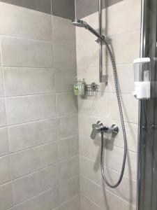a shower with a shower head in a bathroom at Pepleri Studio 20 in Tartu