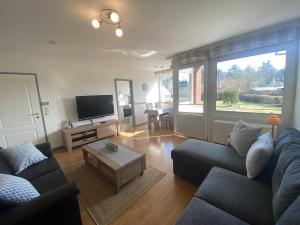 a living room with a couch and a tv at Föhrer Schatztruhe - EG - mit Garage in Wyk auf Föhr