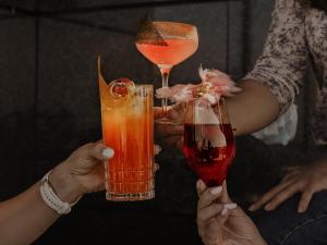 two people holding up drinks in their hands at Hyatt Regency Sofia in Sofia +69 photos
