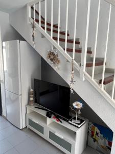 a living room with a tv and a staircase at Casa Ucraniana Wi-Fi fibra in Costa Calma
