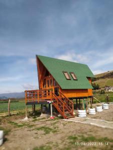 a large wooden house with a green roof at Glamping y Cabañas el Encanto los Geranios in Tota