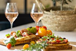 two glasses of wine and food on a table at Hotel Indigo Cagnes-sur-Mer by IHG in Cagnes-sur-Mer