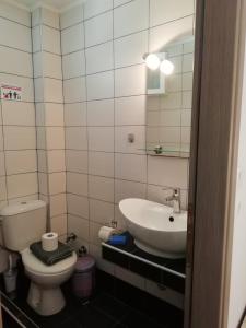 a bathroom with a sink and a toilet and a mirror at Aiolos II in Skala Potamias