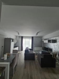 uma sala de estar com sofás e uma mesa e uma sala de jantar em Apartament Mamaia-Nord em Mamaia Nord – Năvodari